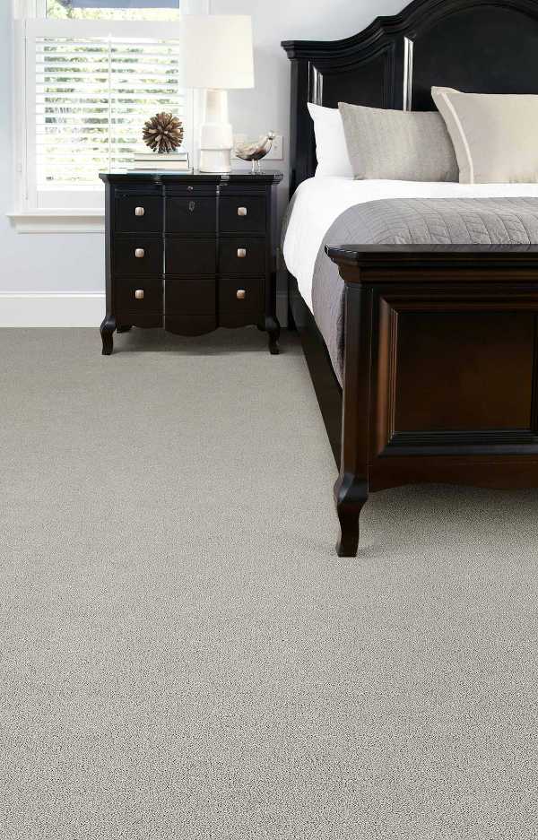 traditional bedroom with neutral carpet and dark wood furniture